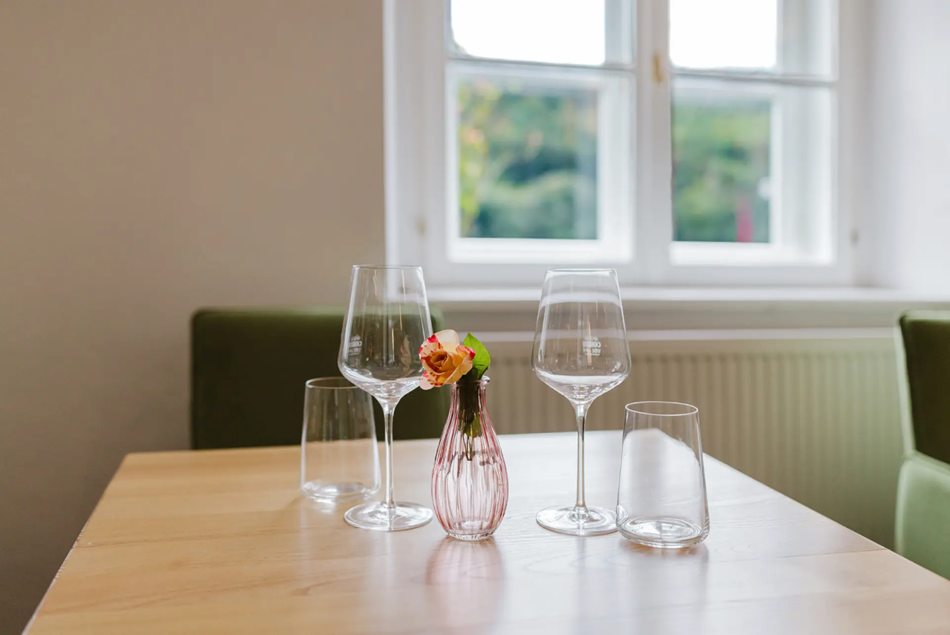 Liebevoll gedeckter Tisch mit Weingläsern und kleiner Blumenvase im Aggsteiner Hof